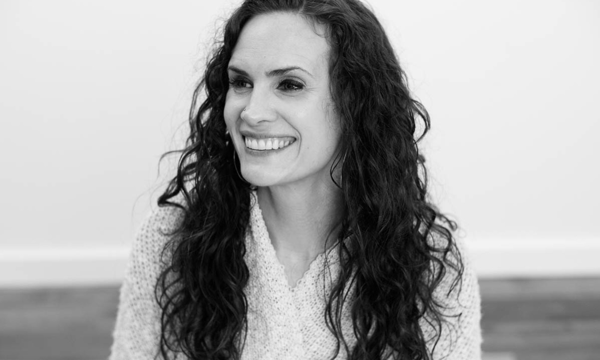 Black and white profile view photography of Janelle Leonard, a white woman with dark long wavy hair.